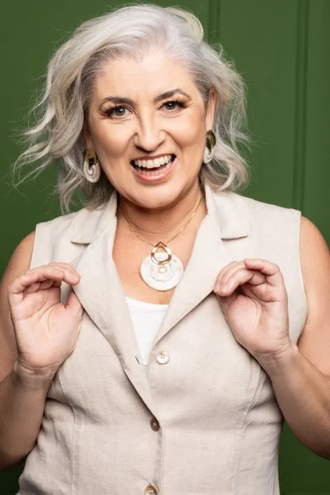 Retrato de Marcia Campetti mostrando um pingente de cerâmica